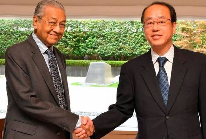 Prime Minister Tun Dr Mahathir Mohamad shakes hands with special adviser to the Japanese prime minister, Hiroto Izumi, in Fukuoka August 8, 2019. u00e2u20acu201d Bernama pic