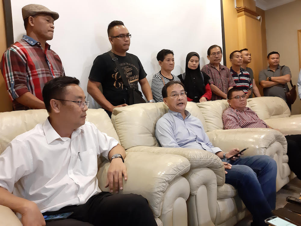 Sarawak PKR chief Baru Bian (seated, centre) with some of the family members (standing behind) at the press conference in Kuching August 9, 2019. u00e2u20acu201d Picture by Sulok Tawie