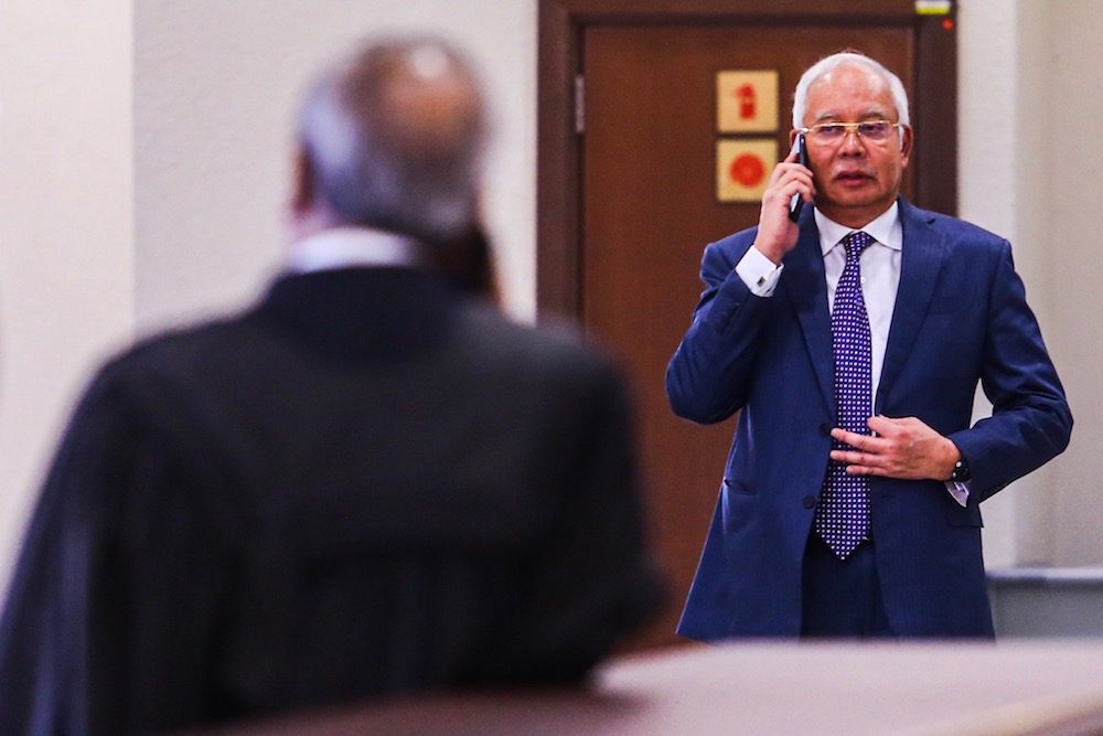 Datuk Seri Najib Razak makes a call during recess for his SRC International trial at the Kuala Lumpur Courts Complex August 19, 2019. u00e2u20acu201d Picture by Hari Anggara