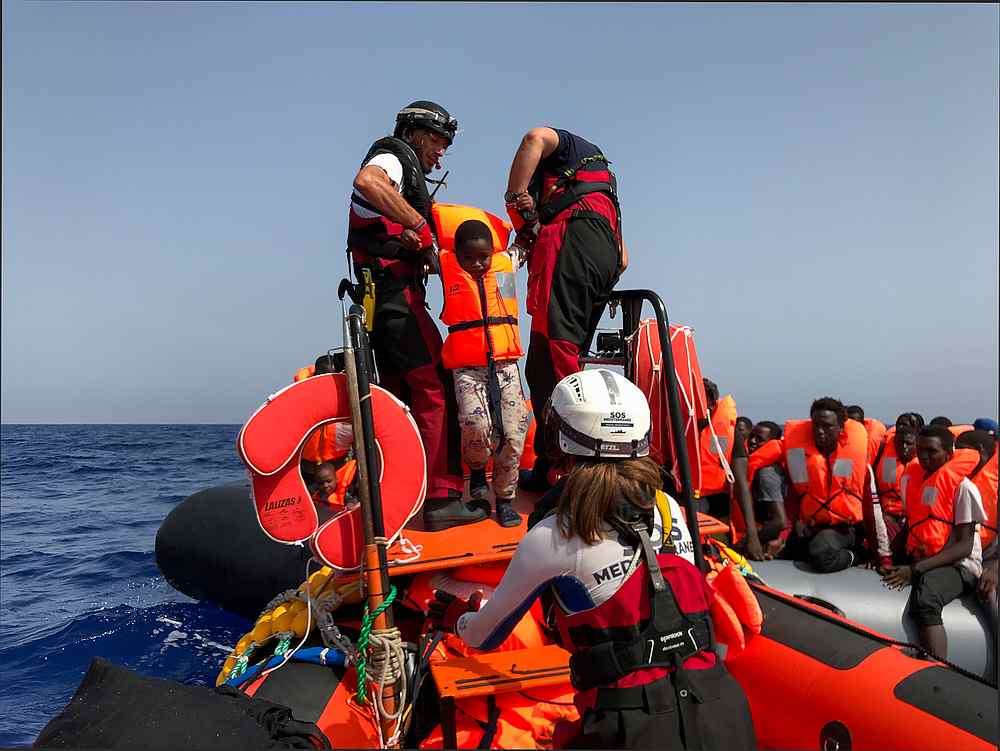 Ocean Viking crew members help a child climb on board an inflatable dinghy during their rescue operation in the Mediterranean Sea August 9, 2019. u00e2u20acu201d AFP pic