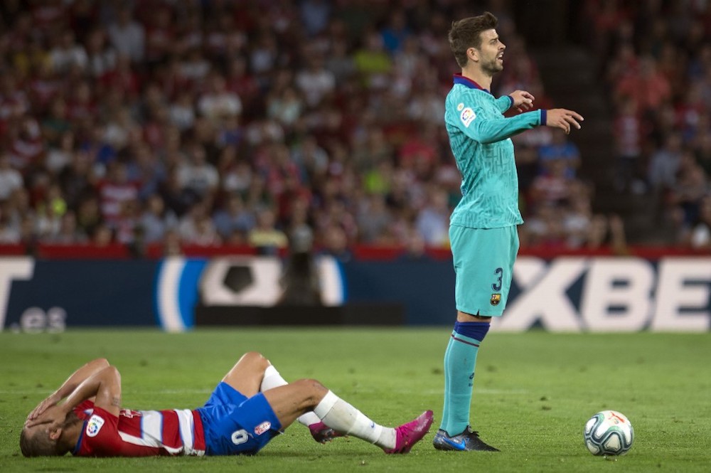 Granadau00e2u20acu2122s Roberto Soldado lies on the field while Barcelonau00e2u20acu2122s Gerard Pique gestures during their La Liga match at Nuevo Los Carmenes stadium in Granada September 21, 2019. u00e2u20acu201d AFP pic