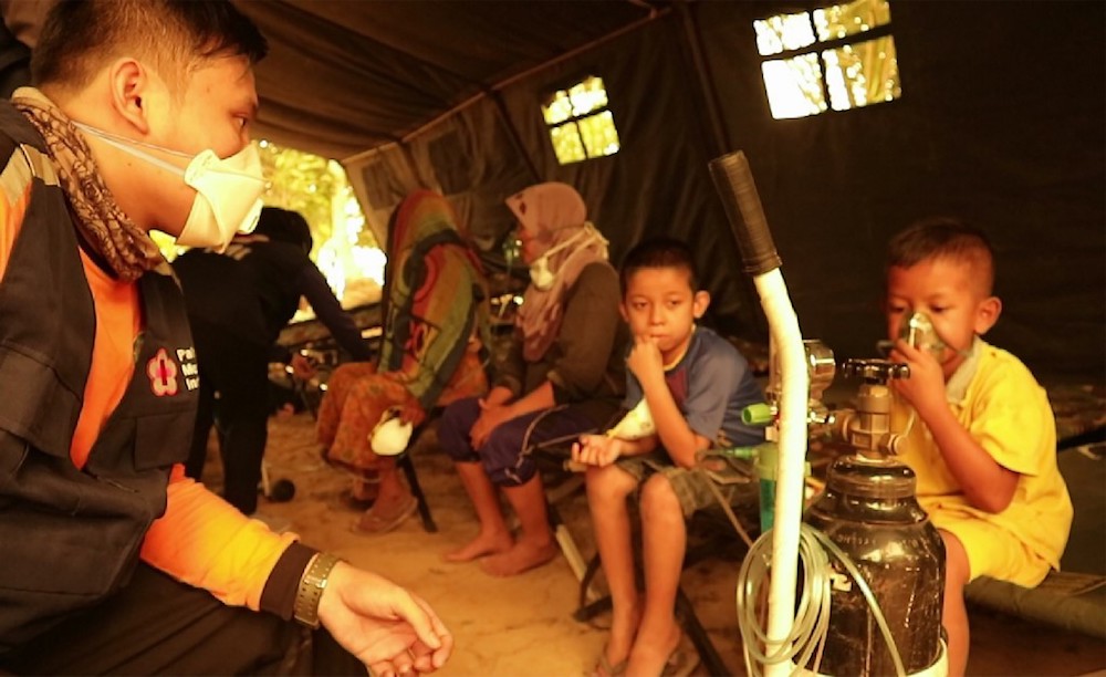 Children get a dose of oxygen from a Red Cross volunteer at a village in Jambi September 24, 2019. u00e2u20acu201d AFP pic