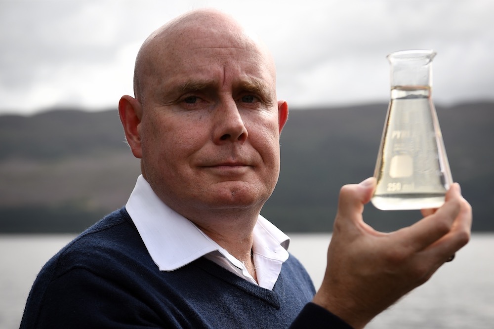 University of Otago geneticist, Professor Neil Gemmell poses with a beaker of water on the shores of Loch Ness in Scotland September 5, 2019. u00e2u20acu201d AFP pic