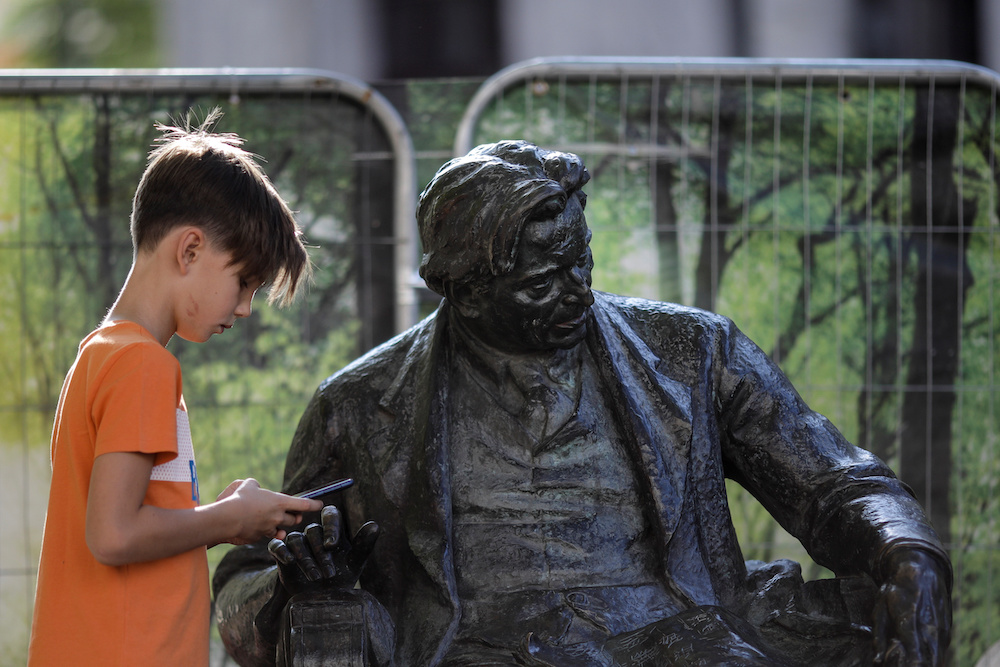 Radu Matei looks at his phone next to the statue of George Enescu before attending a walking tour of Bucharestu00e2u20acu2122s hidden places organised as part of the George Enescu Festival, in Bucharest September 6, 2019. u00e2u20acu201d Inquam Photos/Octav Ganea handout via Reu