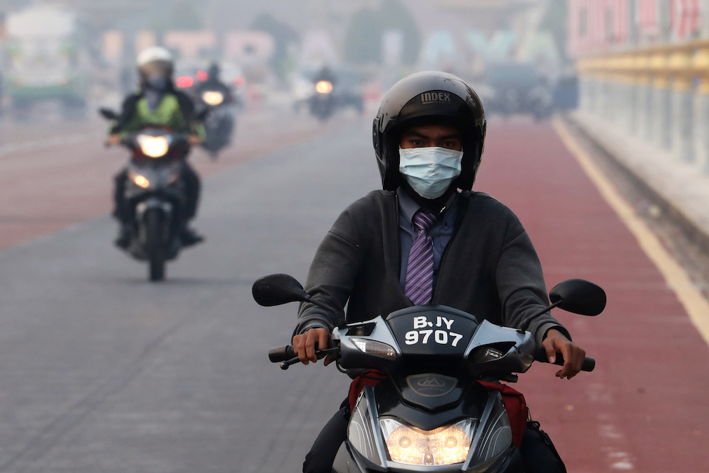 A man rides on a motorcycle in the haze in Putrajaya September 17, 2019. u00e2u20acu201d Reuters pic