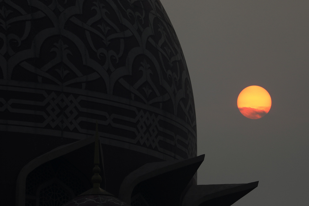The sun sets above a mosque on a hazy day in Putrajaya September 17, 2019. u00e2u20acu201d Reuters pic