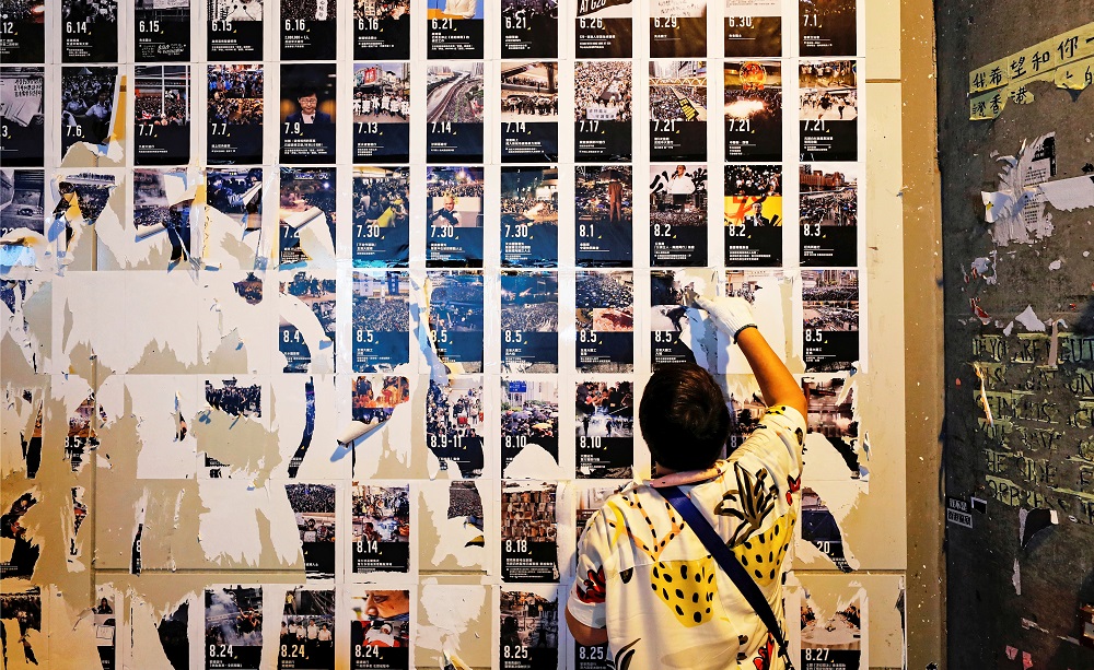 A pro-China supporter cleans up u00e2u20acu02dcLennon Wallsu00e2u20acu2122 of anti-government posters and memo notes outside Yuen Long MTR station in Hong Kong September 21, 2019. u00e2u20acu201d Reuters pic