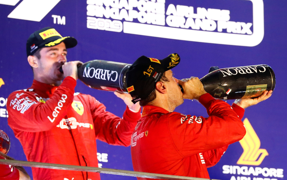 Race winner Ferrariu00e2u20acu2122s Sebastian Vettel and second placed Ferrariu00e2u20acu2122s Charles Leclerc celebrate by drinking sparkling wine on the podium after the Singapore Grand Prix September 22, 2019. u00e2u20acu201d Reuters pic