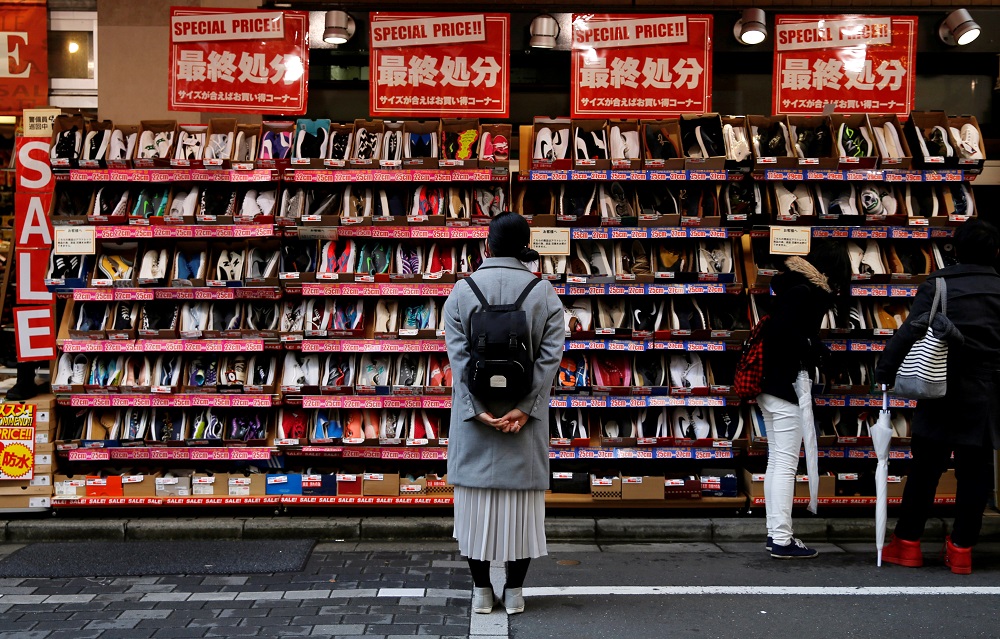 A woman looks at shoes on sale at an outlet store in Tokyou00e2u20acu2122s shopping district December 1, 2016. u00e2u20acu201d Reuters pic