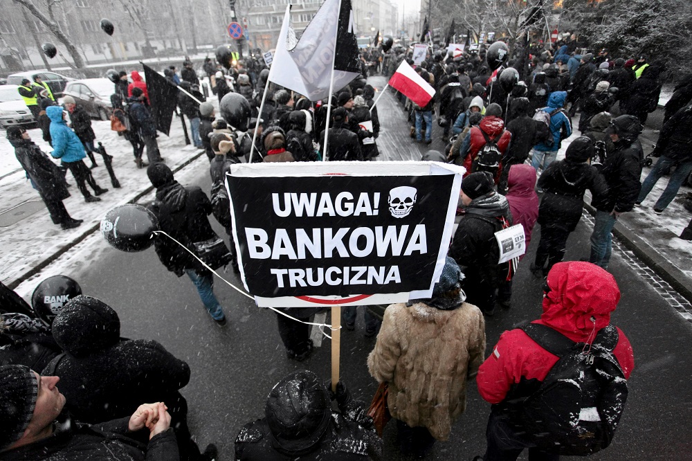 Polish homeowners, who have mortgages in Swiss francs, demonstrate in front of the Parliament in Warsaw, January 15, 2016. The banner reads, u00e2u20acu02dcWarning! Banks poisonu00e2u20acu2122. u00e2u20acu201d Picture by Agencja Gazeta/Slawomir Kaminski via Reuters
