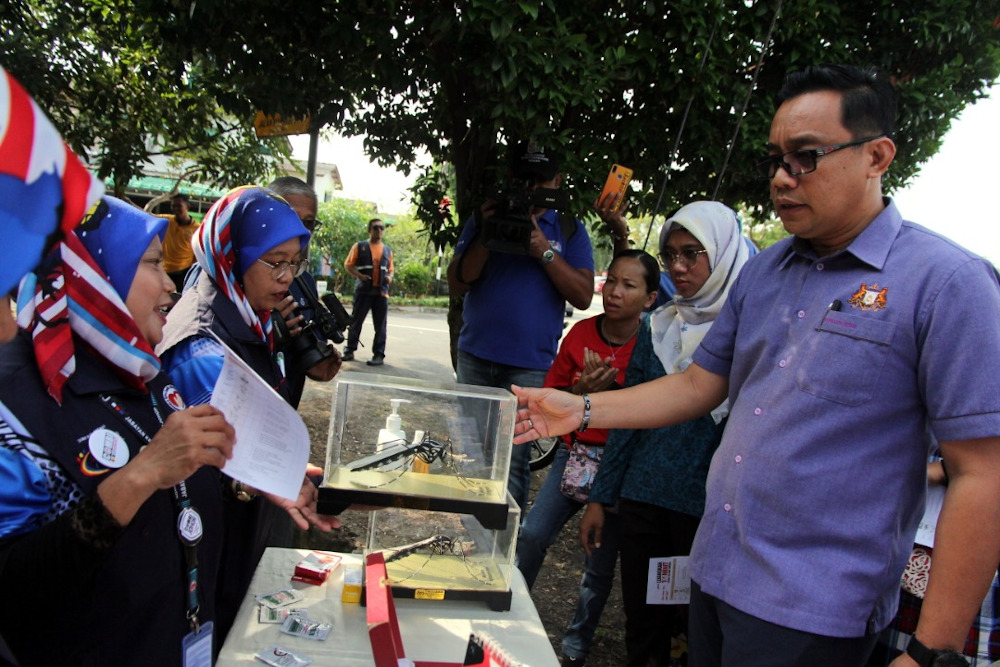 Johor Health, Culture and Heritage Committee chairman Mohd Khuzzan Abu Bakar (far right) with paraphernalia on dengue awareness during his visit to Taman Damai Jaya in Skudai, Johor Baru September 3, 2019. u00e2u20acu201d Picture by Ben Tan
