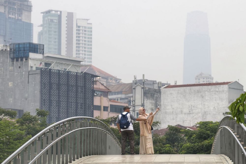 Tourists take a selfie as haze blankets Kuala Lumpur September 12, 2019. — Picture by Ahmad Zamzahuri