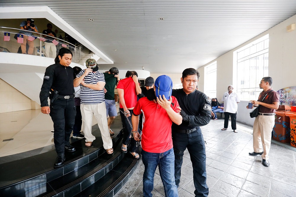 Six personnel from the National Registration Department is led to George Town Sessions Court September 12, 2019. u00e2u20acu201d Picture by Sayuti Zainudin