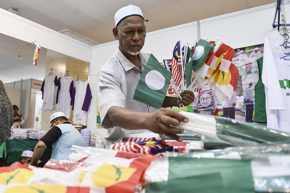 A man sells PAS-Umno flags during Himpunan Penyatuan Ummah (Muslim Unity Rally) at Putra World Trade Centre in Kuala Lumpur September 13, 2019. — Picture by Miera Zulyana