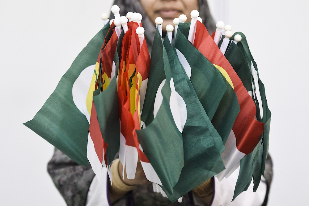 A woman holds PAS-Umno flags during Himpunan Penyatuan Ummah (Muslim Unity Rally) at Putra World Trade Centre in Kuala Lumpur September 13, 2019. u00e2u20acu201d Picture by Miera Zulyana