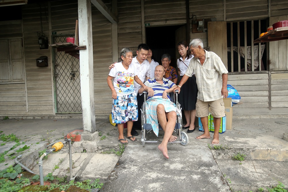 Low and colleagues help the Ng siblings as they leave their dilapidated family home.