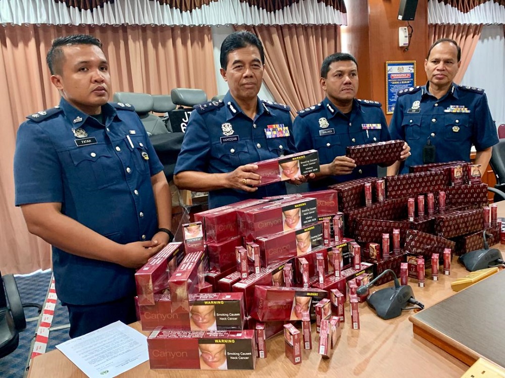 Johor Customs Department director Datuk Mohammad Hamidan Maryani (2nd left) with the contraband cigarettes during the media conference at Menara Kastam Johor in Johor Baru September 17, 2019. u00e2u20acu201d Picture by Ben Tan