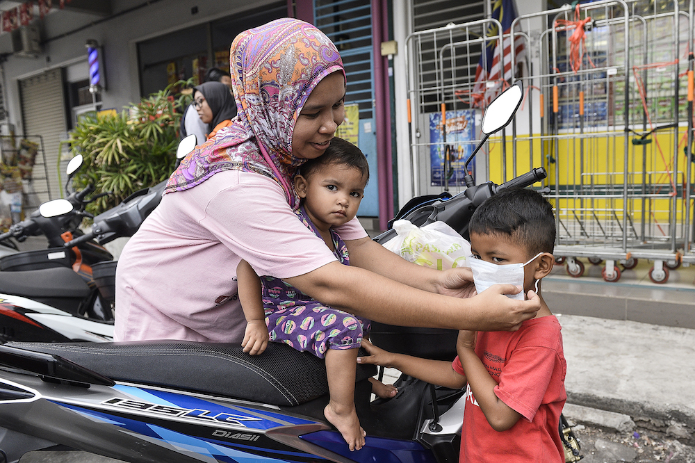 A mother helps her son with his face mask in Klang September 18, 2019. u00e2u20acu201d Picture by Miera Zulyana