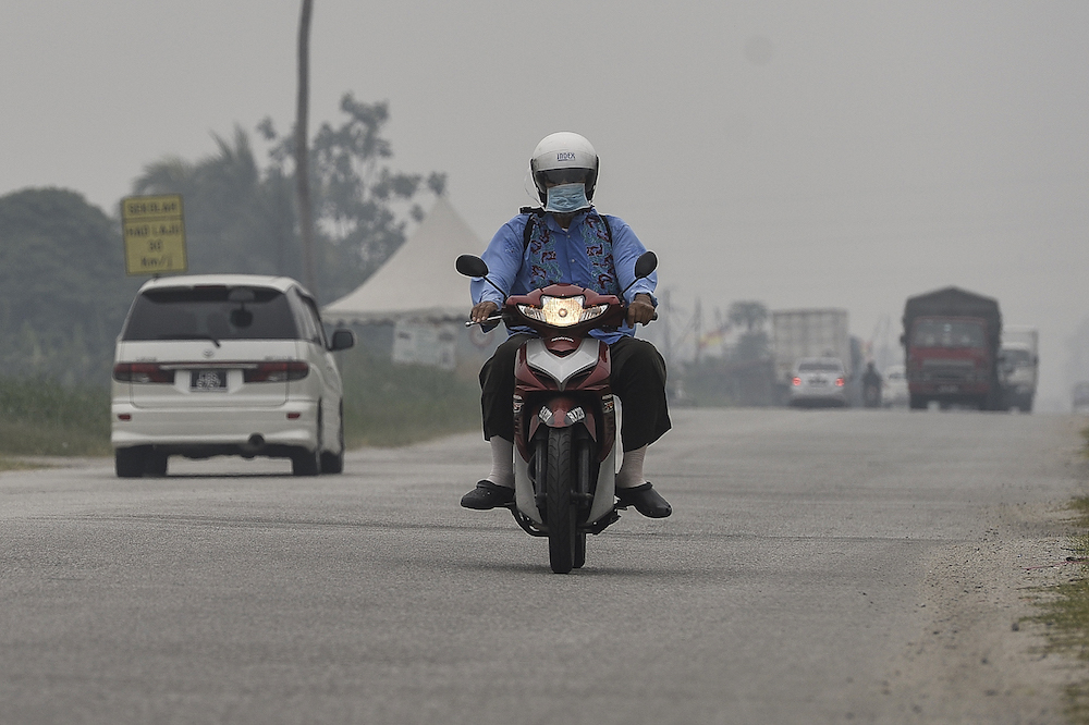 A motorcyclist travels along a road in Kampung Johan Setia in Klang September 18, 2019. u00e2u20acu201d Picture by Miera Zulyana