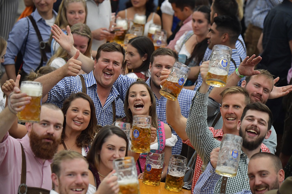 People in traditional Bavarian dress raise their beer glasses in a beer tent at the Oktoberfest beer festival in Munich. u00e2u20acu201d AFP pic