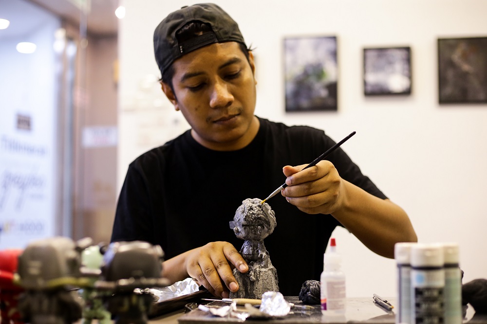 Ajim Juxta works on one of his figurines of Tun Dr Mahathir at the 'Tun M Custom Show’ in Kuala Lumpur.