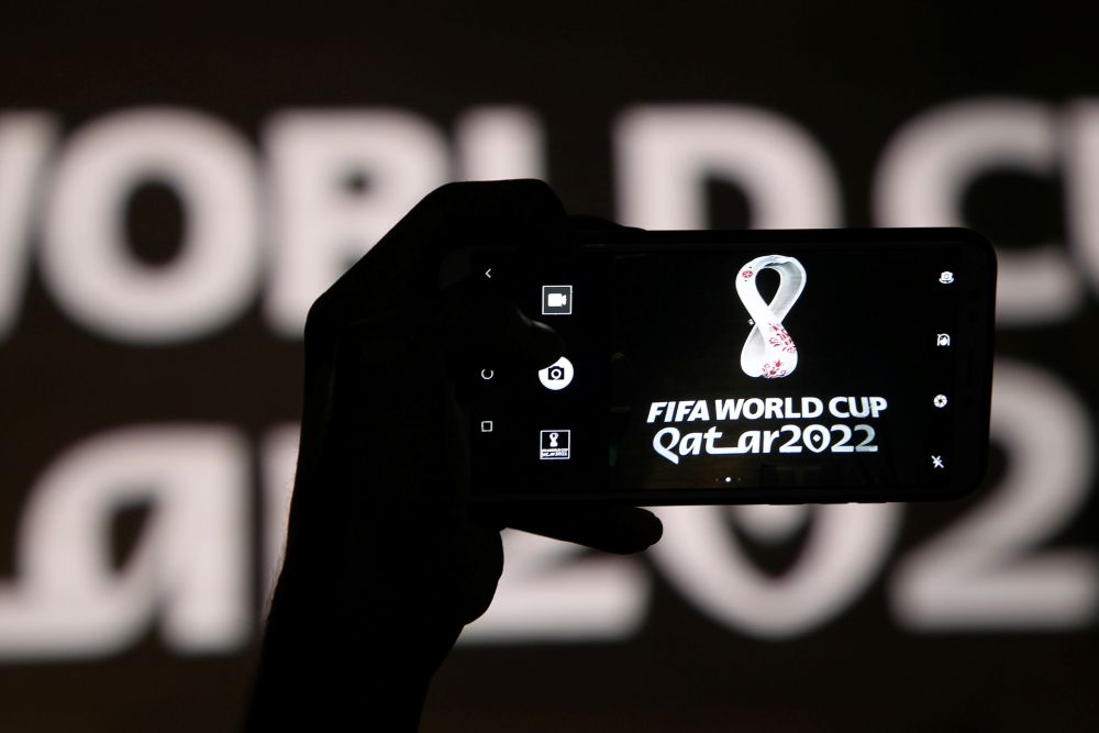 A man takes a picture of the tournament's official logo for the 2022 Qatar World Cup as displayed on the wall of amphitheater, in Doha, Qatar, September 3, 2019. u00e2u20acu201d Reuters pic