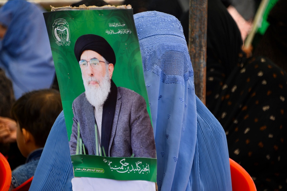 In this picture taken on September 18, 2019, a woman holds an electoral poster of presidential candidate Gulbuddin Hekmatyar during a campaign rally in Herat. u00e2u20acu201d AFP pic        