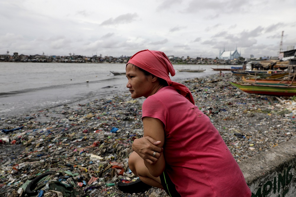Lisa Jorillo, who regularly purchases products in sachet packaging, looks at the garbage-filled shore of Baseco Beach in Tondo, Manila, Philippines July 17, 2019. — Reuters pic