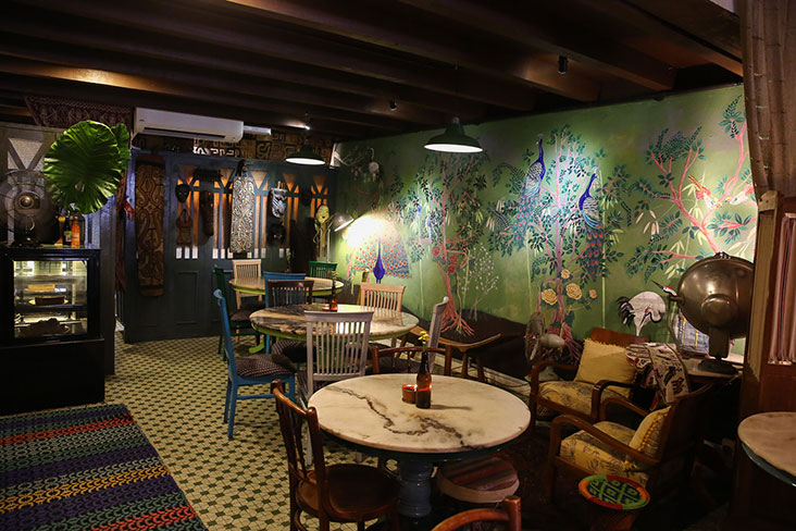 The bold and beautiful hand-painted mural with a Chinoiserie theme of exotic birds in a garden of trees and flowers take centre stage in the restaurant