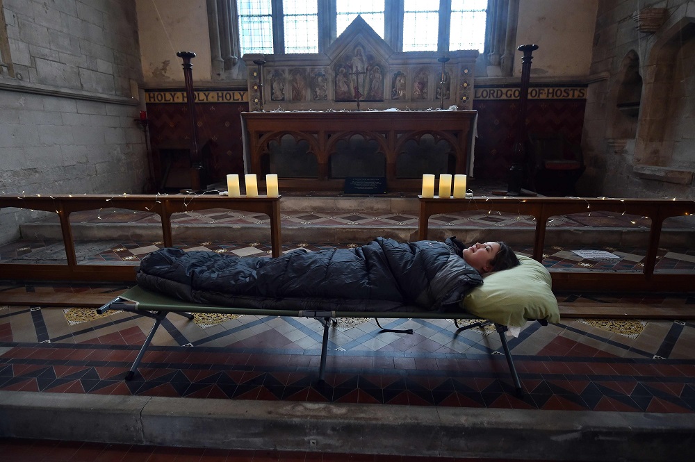 Guest Andrea Stewart tries out her bed before nightfall at St Mary’s Church, where guests can pay to stay overnight in what is known as ‘champing’, in Edlesborough, Buckinghamshire September 2, 2019. — AFP pic