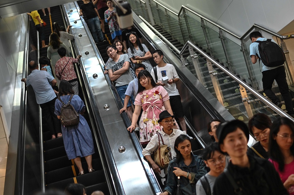 This photo taken on August 30, 2019 shows transgender Alice (centre in pink) as she rides an escalator at an underground train station in the city of Chengdu in Chinau00e2u20acu2122s Sichuan province. u00e2u20acu201d AFP pic         