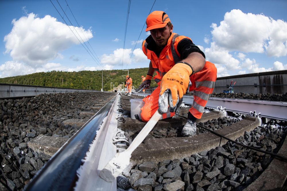 An employee of Germany's public rail operator Deutsche Bahn paints the rail tracks in white color.u00e2u20acu201d AFP pic