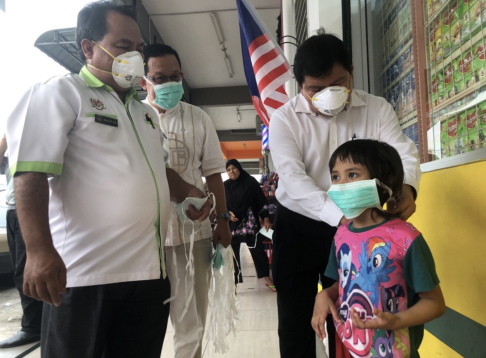 Selangor Environment, Green Technology, Science, Technology and Innovation and Consumer Affairs Committee chairman Hee Loy Sian (right) distributes face masks to the public in Johan Setia, Klang September 13, 2019. u00e2u20acu201d Bernama pic