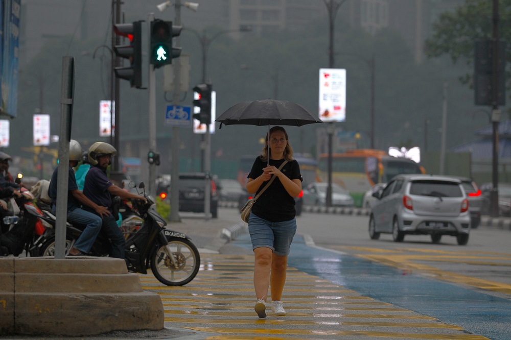A tourist uses an umbrella to shelter from the rain in Kuala Lumpur September 18, 2019. u00e2u20acu201d Bernama pic