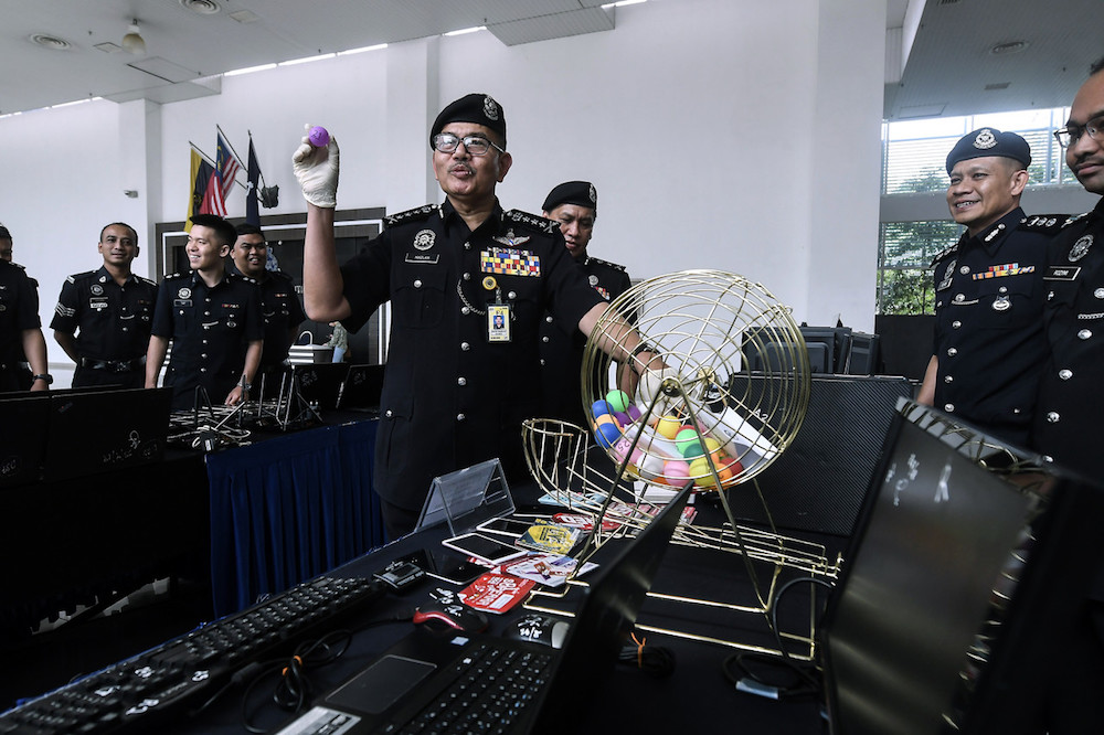 Kuala Lumpur police chief Datuk Seri Mazlan Lazim poses for pictures with some of the seized gambling equipment at the Kuala Lumpur Contingent Police Headquarters September 24, 2019. u00e2u20acu201d Bernama pic