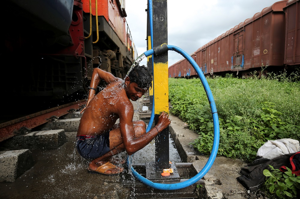 Prakash Nagre washes himself at Aurangabad railway station, Aurangabad India, August 2, 2019. — Reuters pic