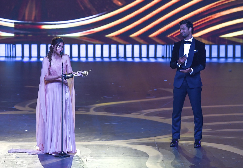 Bollywood actor Alia Bhatt speaks after receiving the Best Performance in a Leading Role — Female award for her movie ‘Raazi’ as actor Vicky Kaushal looks on during the 20th International Indian Film Academy (IIFA) Awards at NSCI Dome in Mumbai September 18, 2019. — AFP pic