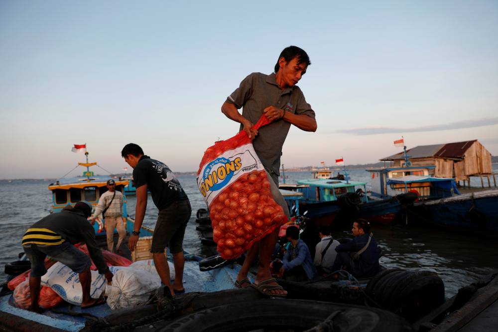 People unload onions from a wooden boat as they arrive from Balikpapan at a port in North Penajam Paser regency, East Kalimantan province, Indonesia August 28, 2019. ― Reuters pic