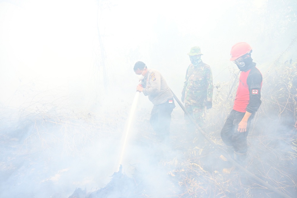 Indonesian firefighters spray water to help extinguish a fire in Kampar September 16, 2019. u00e2u20acu201d AFP pic         