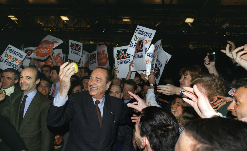 In this file photo taken March 24, 1995 French presidential candidate Jacques Chirac holds an apple in Bordeaux during an election campaign meeting while Alain Juppe (2nd left), his campaign director and his future prime minister. u00e2u20acu201d AFP pic 