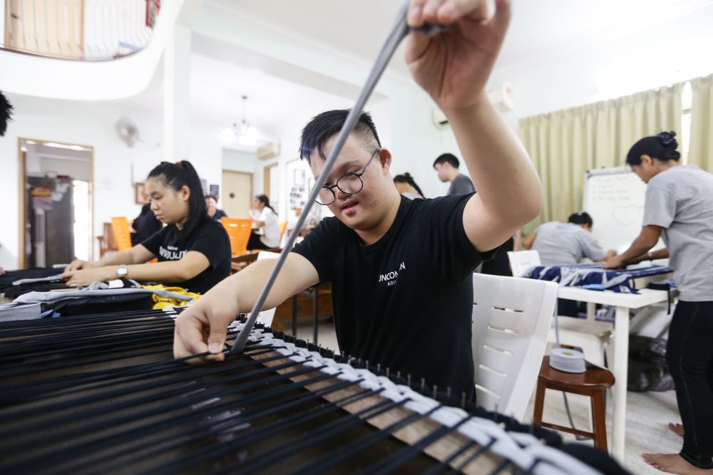 See Choy Yuen, one of the special needs youths at Gem & Bread who loves to dance, enjoys creative tasks like weaving floor mats. u00e2u20acu201d Picture by Ahmad Zamzahuri. 