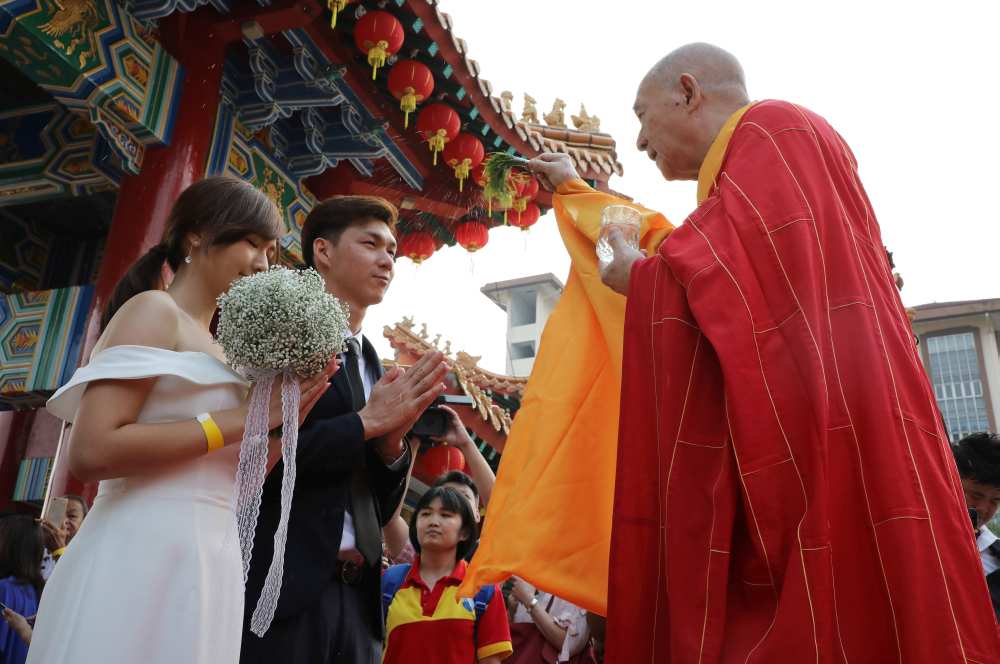 A newly-wed couple is blessed by a priest during a mass wedding at a Chinese temple in Kuala Lumpur September 9, 2019. u00e2u20acu2022 Reuters pic