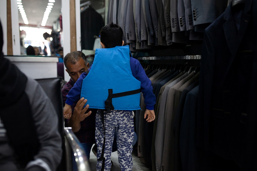  Hanin’s father Zuher, a Palestinian-Syrian refugee, fits his son Osama, 8, with a life jacket, preparing to travel to the Greek Islands on a dinghy, in Izmir, Turkey October 17, 2018. — Reuters pic