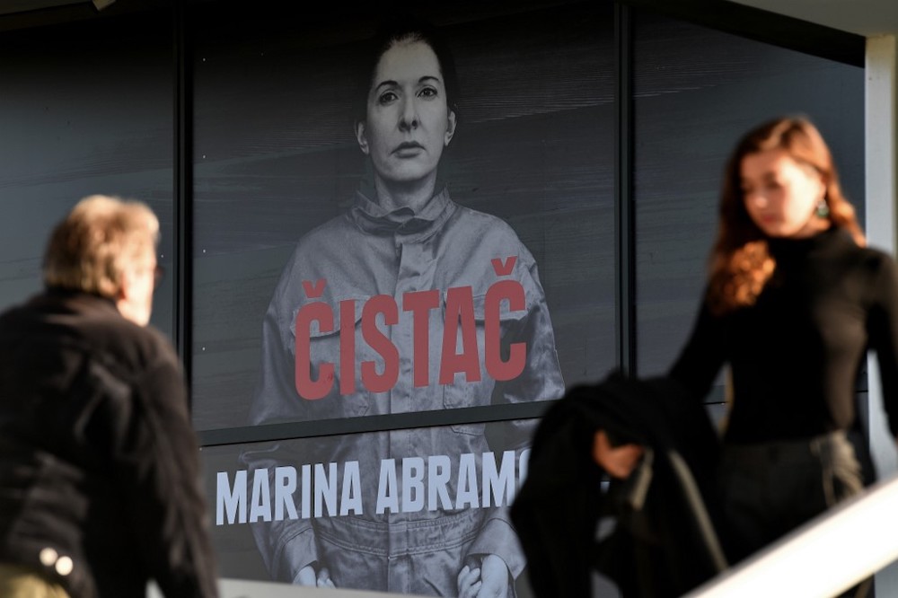 Visitors walk past an exhibition poster for the performance artist Marina Abramovic at the Museum of Modern Art in Belgrade on September 21, 2019, where she opened a retrospective exhibition, called u00e2u20acu02dcThe Cleaneru00e2u20acu2122. u00e2u20acu201d AFP pic