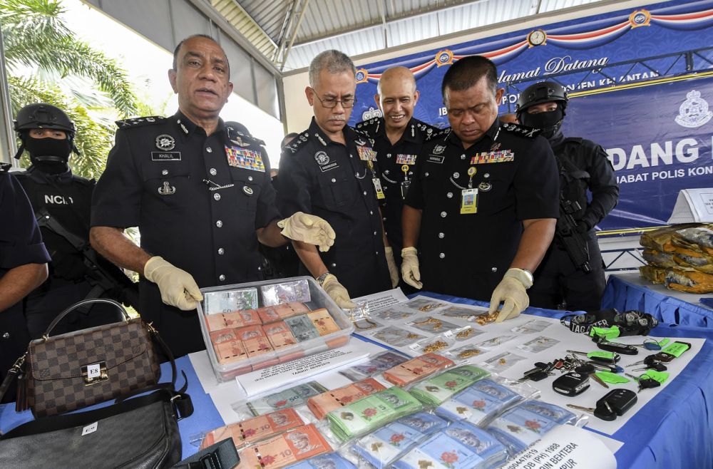 Datuk Mohd Khalil Kader Mohd holds up cash seized in a recent drug bust at the Kelantan Contingent Police Headquarters in Kota Bharu September 10, 2019. u00e2u20acu2022 Bernama pic