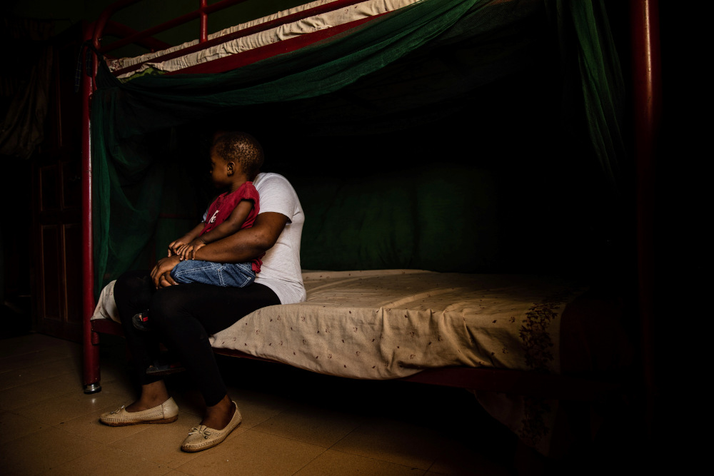 A woman and her child rest June 26, 2019 in Benin City, at one of the shelters of the Society For the Empowerment Of Young Persons, an organisation that rehabilitates and reintegrates women returning from Libya carrying young children often born as the re