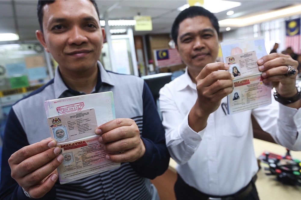 Sulaiman Abd Rashid (kiri) dan Shahrulizam Zainal Abidin menunjukkan passport dan I-kad pekerja pembantu rumah yang dimohon secara dalam talian di Jabatan Imigresen Negeri Sembilan, Seremban 25 Januari, 2019. u00e2u20acu201d Foto Bernama