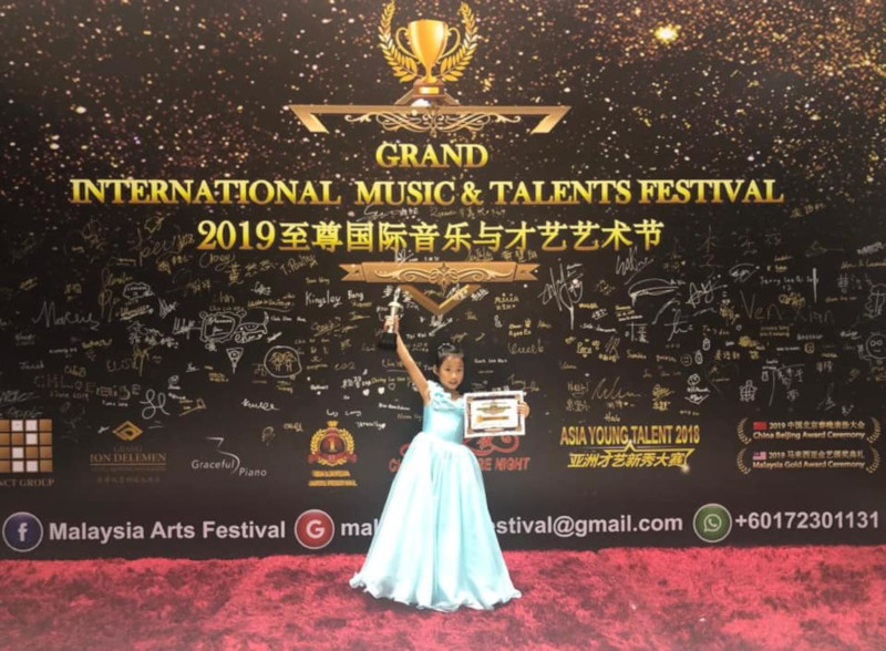 Olivia Lim Ling, 6, celebrating winning the Grand International Music and Talents Festival in Genting Highlands earlier this year. u00e2u20acu201d Picture from Facebook/Ng Kee Ling