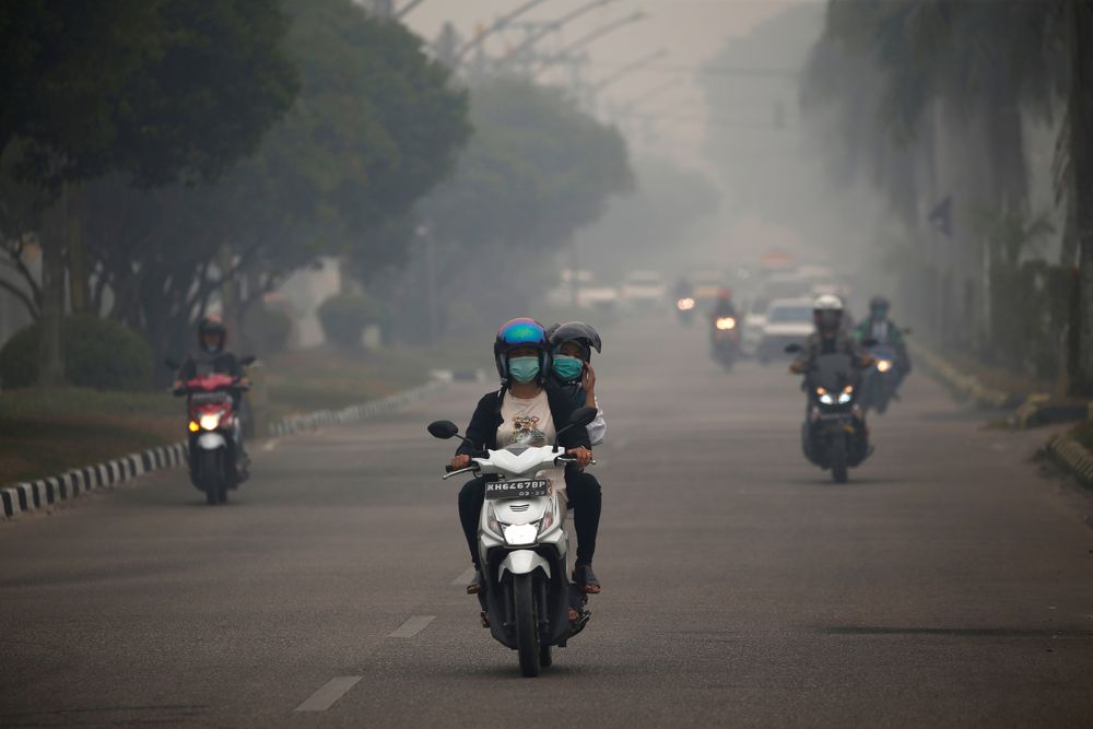 Motorists ride their motorbikes through haze due to a forest fire in Palangka Raya, Central Kalimantan province, Indonesia, September 15, 2019. u00e2u20acu201d Reuters pic