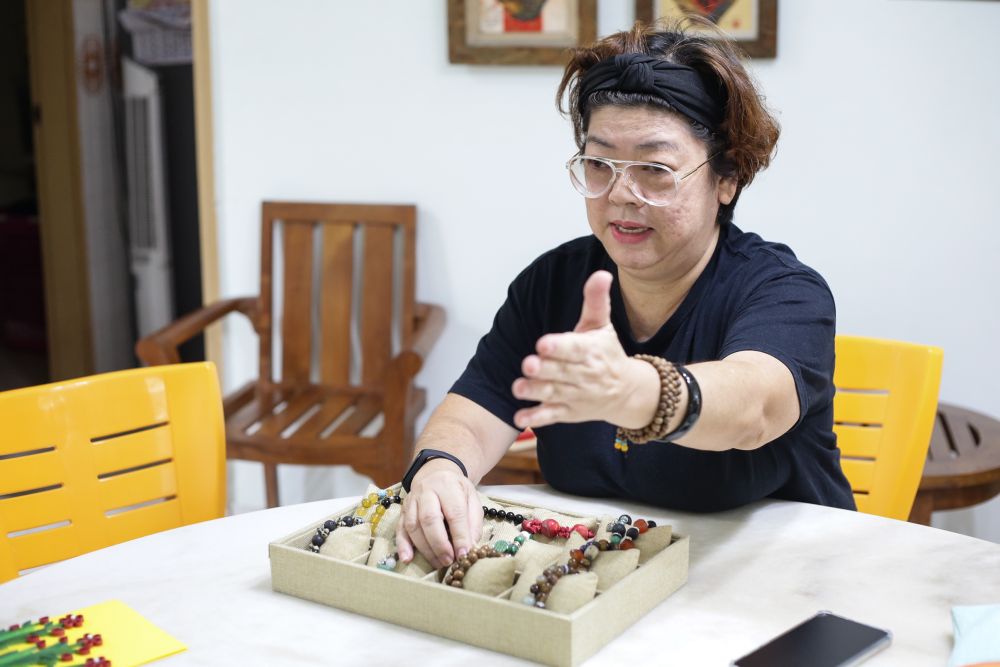 Co-founder Teresa Tan displaying some of the beautiful pieces of jewellery that the youths made. — Picture by Ahmad Zamzahuri